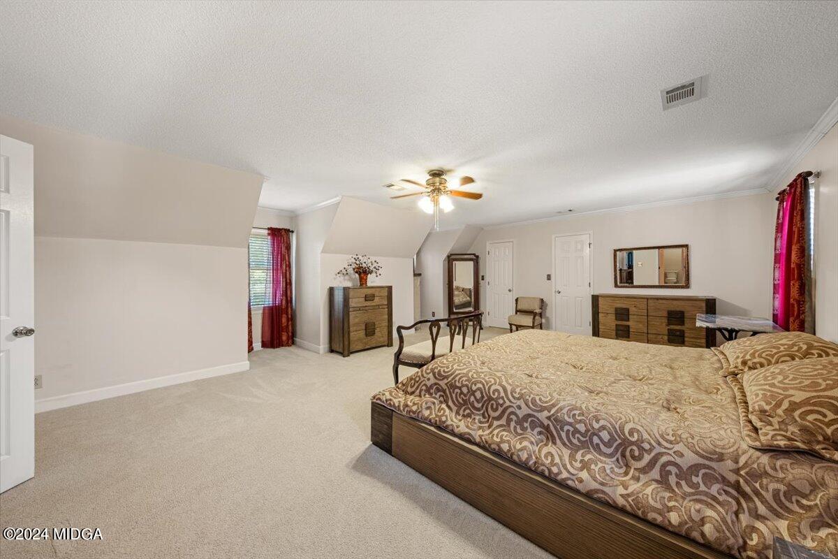 5369 Rivoli Drive Macon, GA 31210 - Photo 29 of 40 a spacious bedroom with a bed and a chandelier