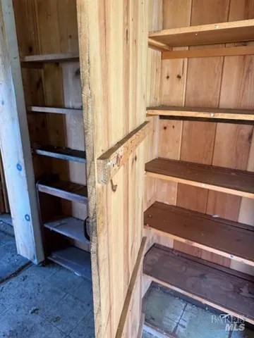 a view of walk in closet with empty racks