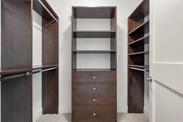 a view of walk in closet with empty racks