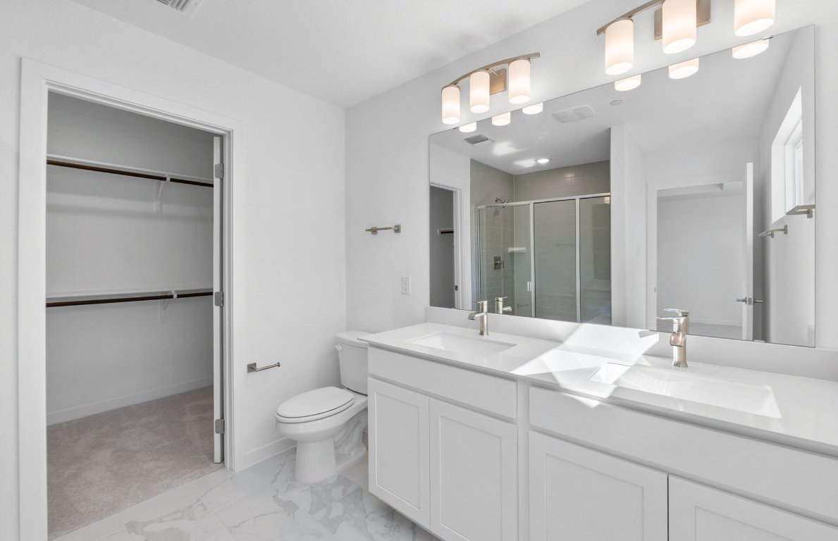 1280 East Main Street, Unit 602 Round Rock, TX 78664 - Photo 11 of 22 a bathroom with a toilet a sink and a mirror