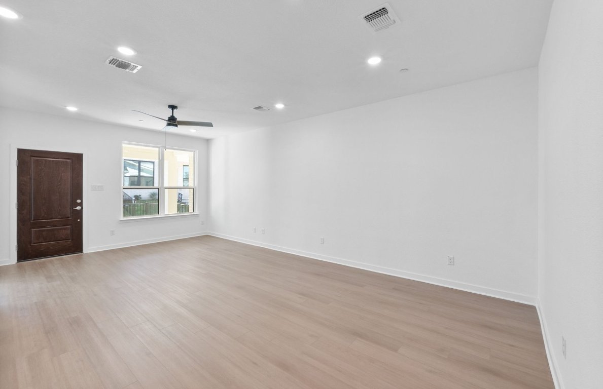 1280 East Main Street, Unit 602 Round Rock, TX 78664 - Photo 6 of 22 an empty room with wooden floor and windows