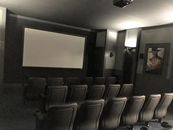 a projector room with a chair a projector and screen