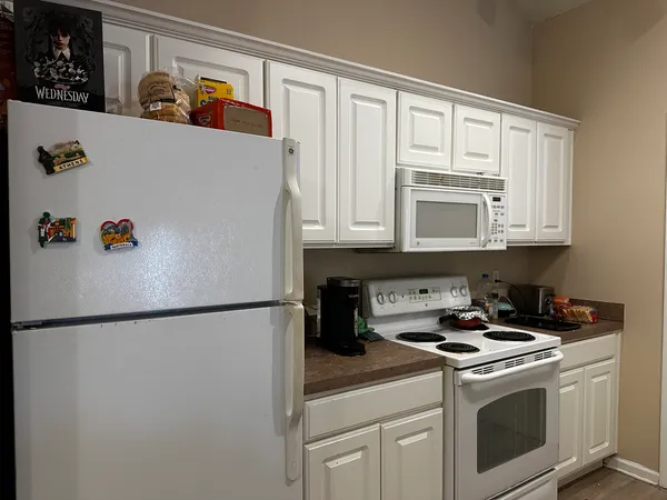 a white refrigerator freezer and a stove sitting inside of a kitchen