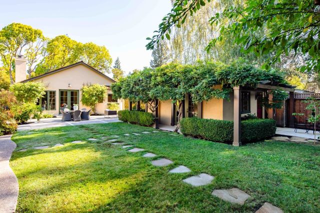 a view of a patio with couches table and chairs and potted plants
