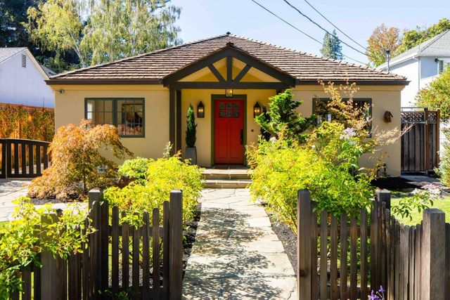 a front view of a house with a yard and fountain in middle