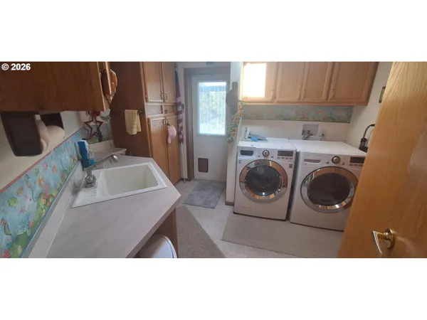 a utility room with dryer washer and a view of kitchen