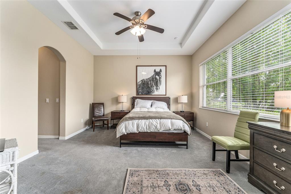 4958 Northwest 35th Ln Road Ocala, FL 34482 - Photo 34 of 66 a spacious bedroom with a bed a couch and a window