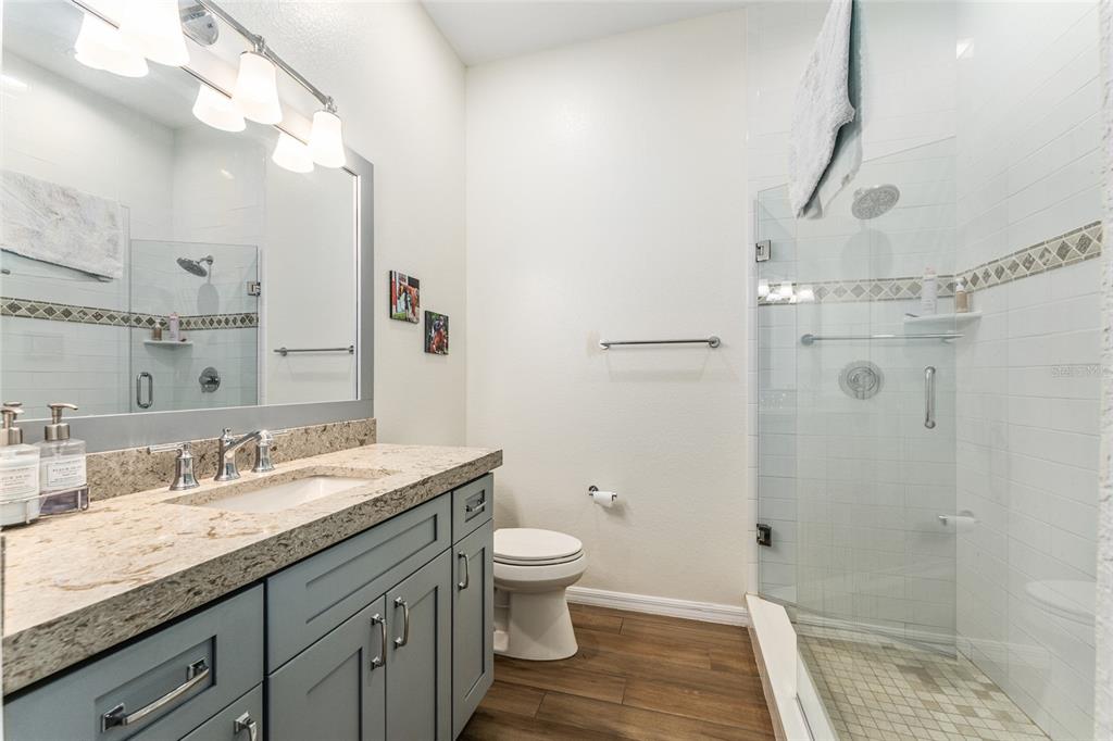 4958 Northwest 35th Ln Road Ocala, FL 34482 - Photo 39 of 66 a bathroom with a granite countertop sink a toilet a shower and a mirror