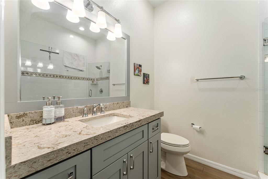 4958 Northwest 35th Ln Road Ocala, FL 34482 - Photo 47 of 66 a bathroom with a granite countertop sink a toilet and a mirror