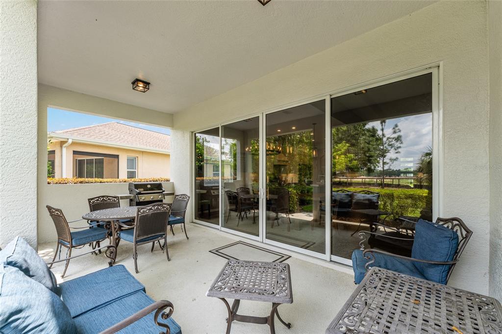 4958 Northwest 35th Ln Road Ocala, FL 34482 - Photo 57 of 66 a living room with furniture and a floor to ceiling window