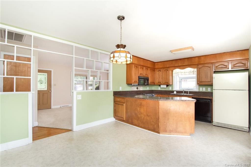 7225 Watercrest Road Charlotte, NC 28210 - Photo 5 of 32 a kitchen with kitchen island a counter top space a sink a refrigerator and a view of living room