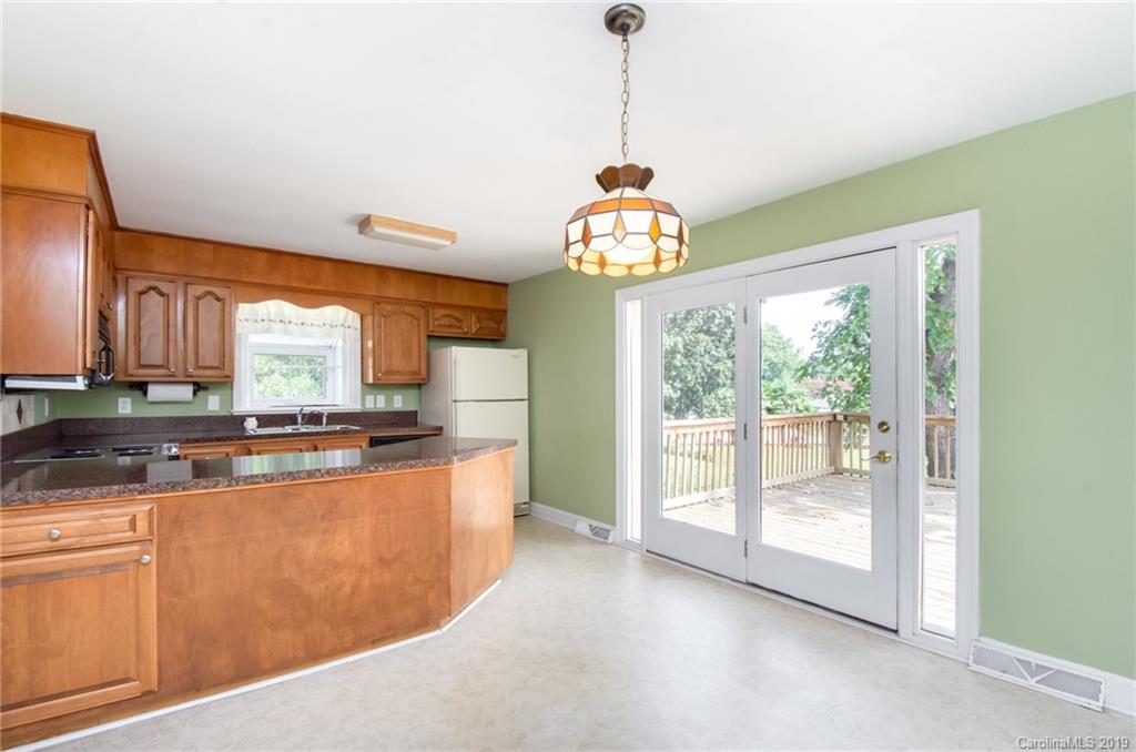 7225 Watercrest Road Charlotte, NC 28210 - Photo 8 of 32 a kitchen with stainless steel appliances granite countertop a stove a sink dishwasher a kitchen island with wooden cabinets and floor