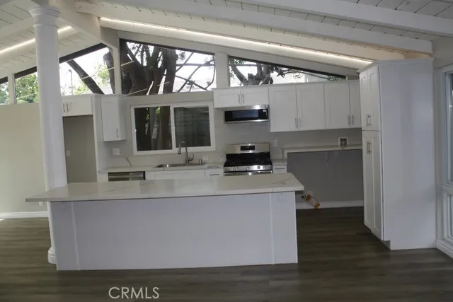 a kitchen with stainless steel appliances a stove and a large window