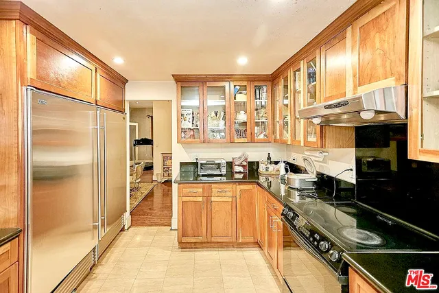 a large kitchen with granite countertop a sink and a refrigerator
