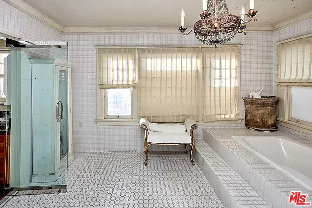 a spacious bedroom with a bed and a chandelier