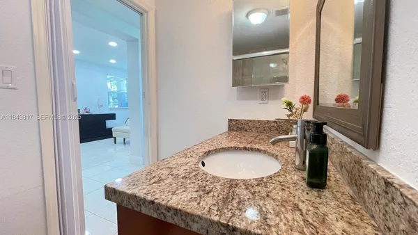a bathroom with a granite countertop sink toilet and shower