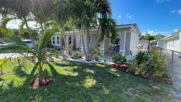 a front view of a house with a yard and potted plants