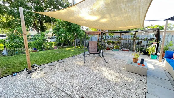 a view of a backyard with a garden and entertaining space