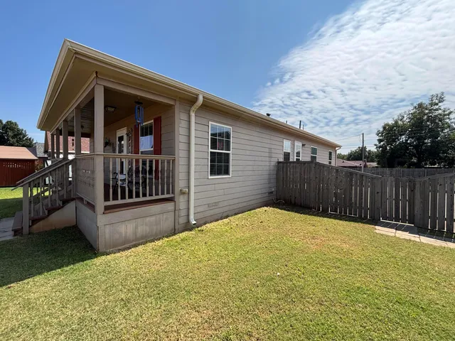 a view of backyard with small cabin and wooden fence