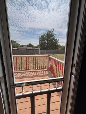 a view of a hallway with wooden floor and stairs