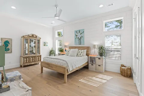 a bedroom with a bed a couch and paintings on the wall