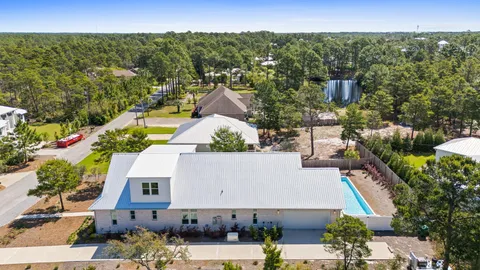 an aerial view of residential houses with outdoor space and parking