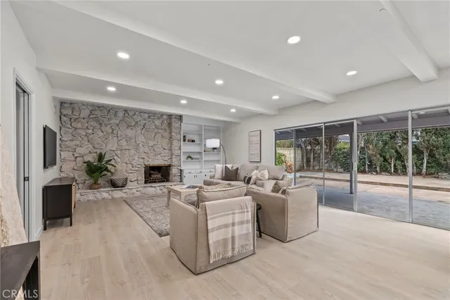 a living room with furniture a fireplace and a floor to ceiling window
