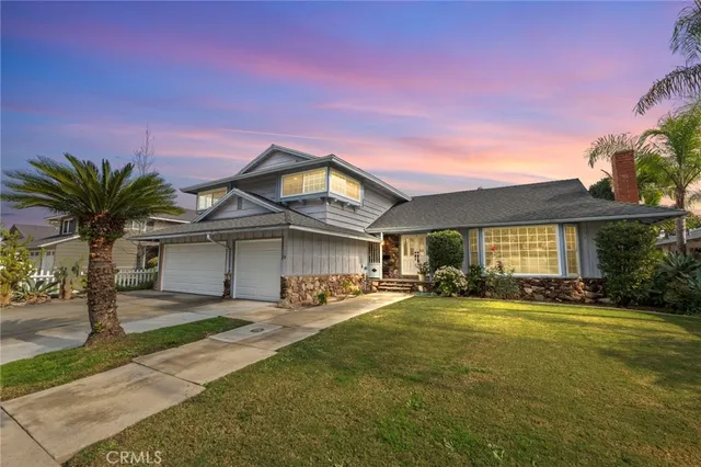 a front view of a house with yard and parking