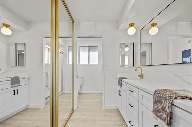 a spacious bathroom with a double vanity sink a mirror and a shower