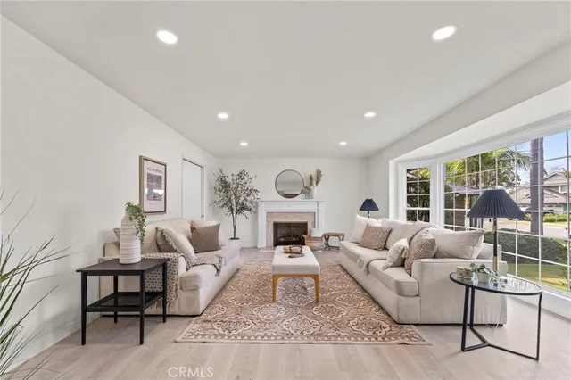 a living room with furniture fireplace and a large window