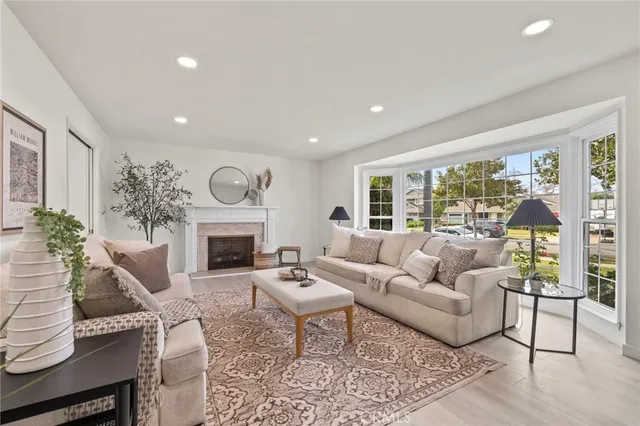 a living room with furniture a fireplace and a large window