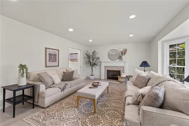 a living room with furniture a fireplace and a window