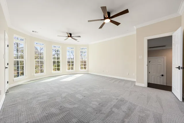 an empty room with a window and a ceiling fan
