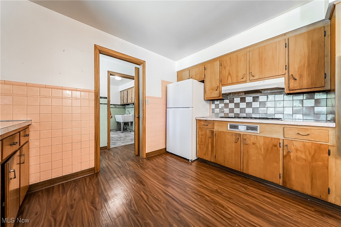550 Cooper Foster Park Road Lorain, OH 44053 - Photo 15 of 50 Kitchen with light countertops, freestanding refrigerator, dark wood finished floors, tile walls, and a wainscoted wall