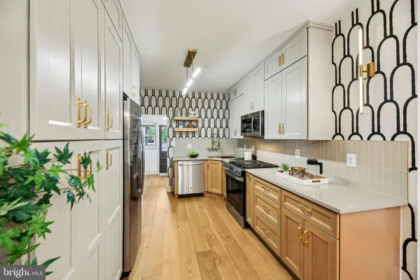 a kitchen with stainless steel appliances granite countertop a refrigerator a stove and a wooden floors