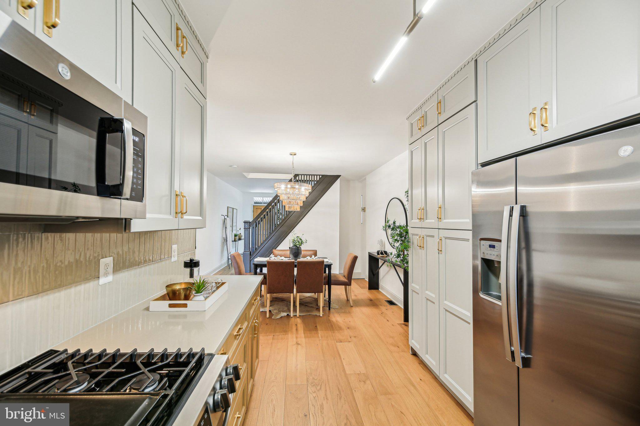 3348 Chestnut Avenue Baltimore, MD 21211 - Photo 12 of 39 a kitchen with stainless steel appliances granite countertop a refrigerator a stove and a wooden floors
