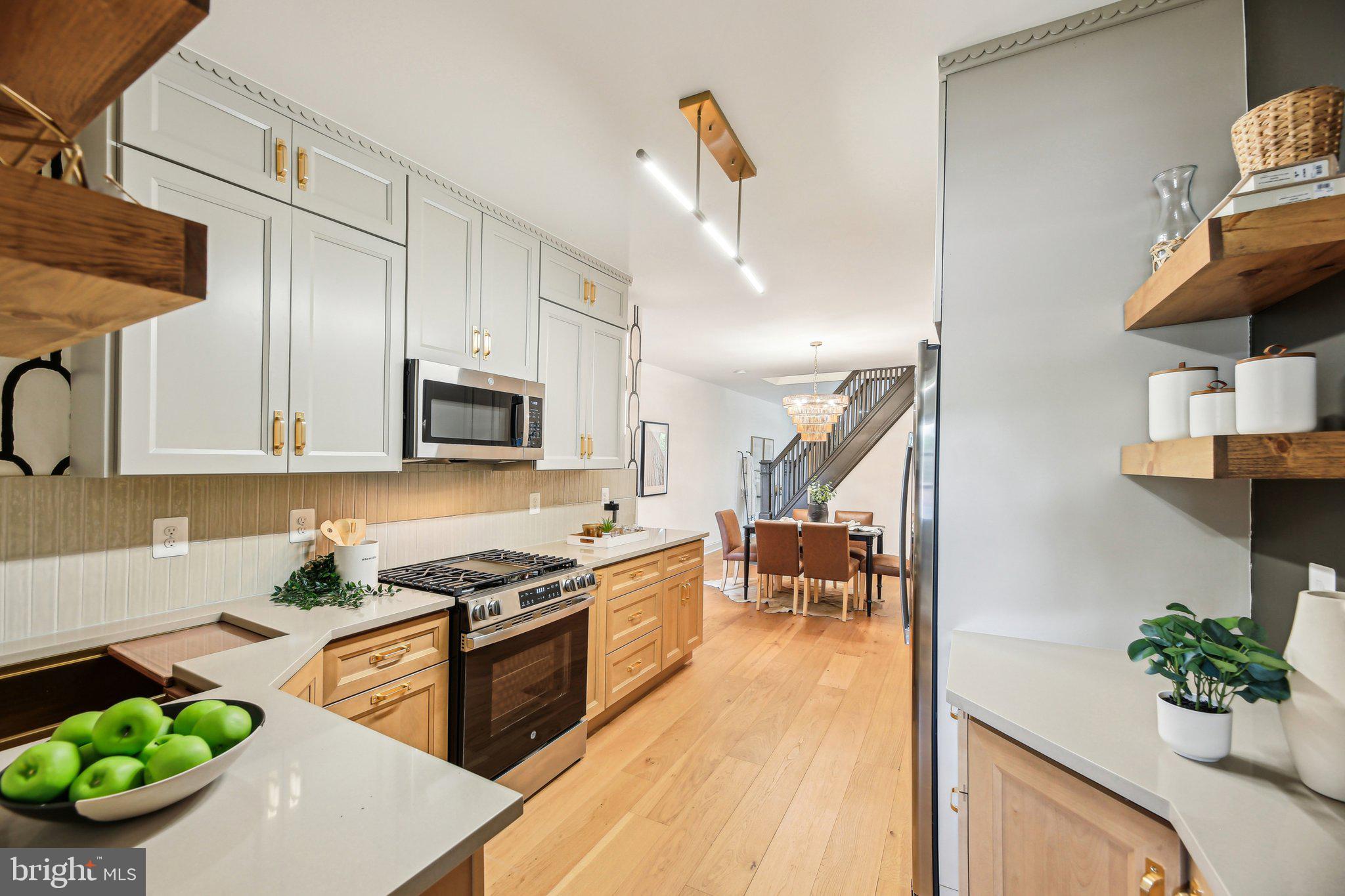 3348 Chestnut Avenue Baltimore, MD 21211 - Photo 14 of 39 a kitchen with stainless steel appliances kitchen island granite countertop a stove a sink and a microwave
