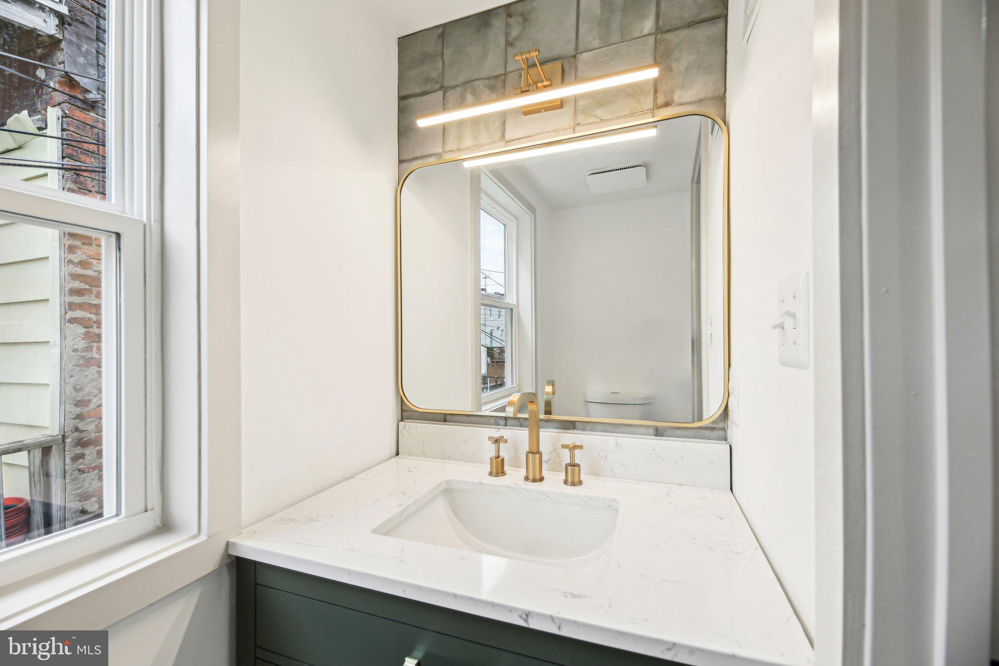 3348 Chestnut Avenue Baltimore, MD 21211 - Photo 17 of 39 a bathroom with a sink and a mirror