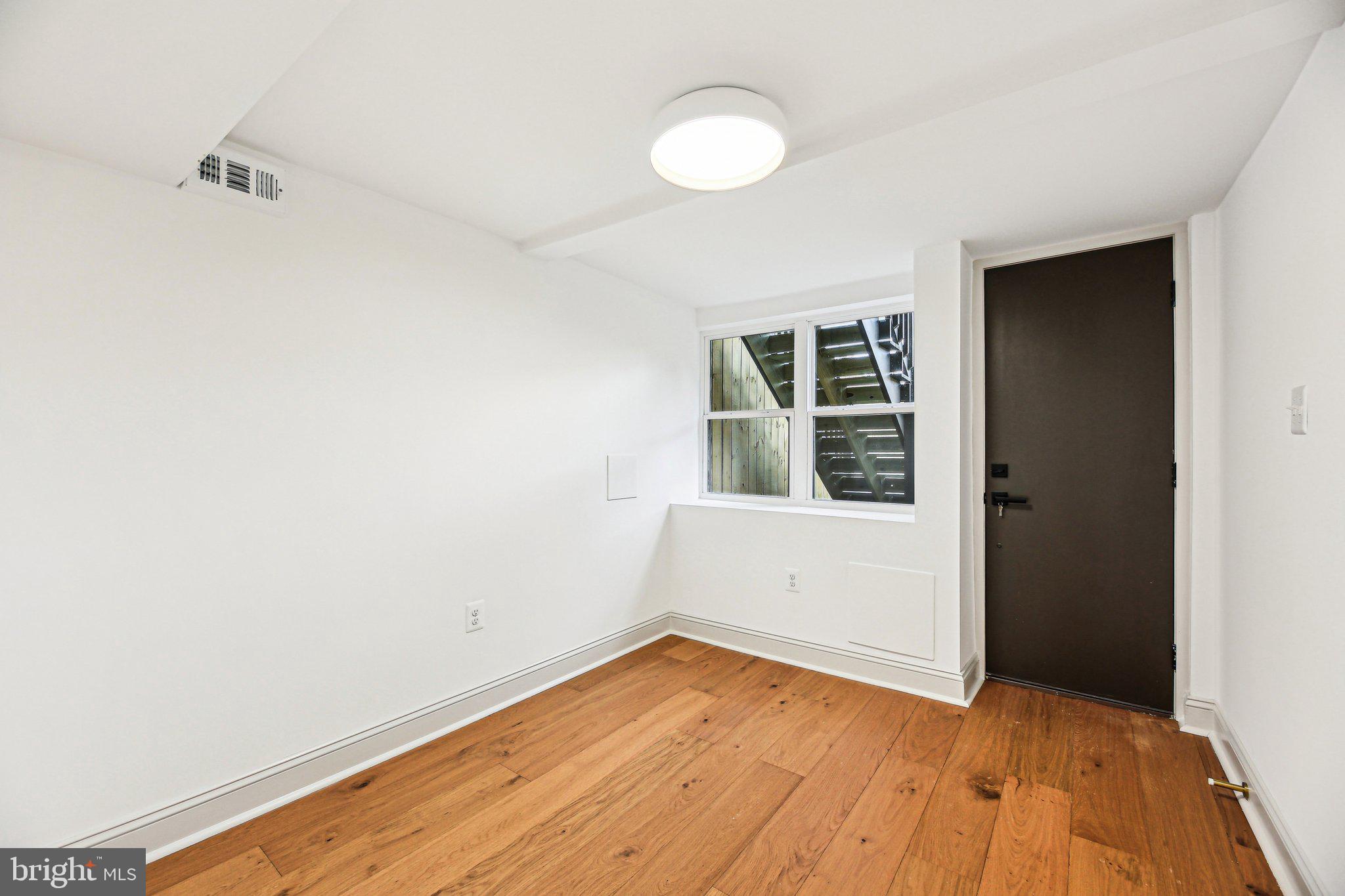 3348 Chestnut Avenue Baltimore, MD 21211 - Photo 35 of 39 a view of an empty room with wooden floor and a window