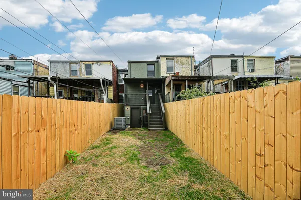 a view of a backyard with wooden fence
