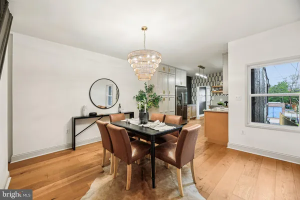 a view of a dining room with furniture a chandelier and wooden floor