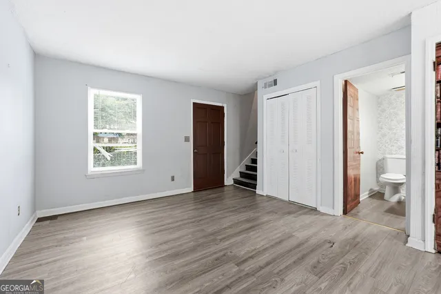 an empty room with wooden floor and a window