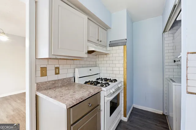 a kitchen with granite countertop a sink and a stove