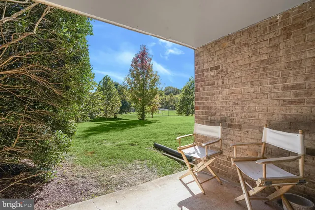 a view of a chair and table in backyard of the house