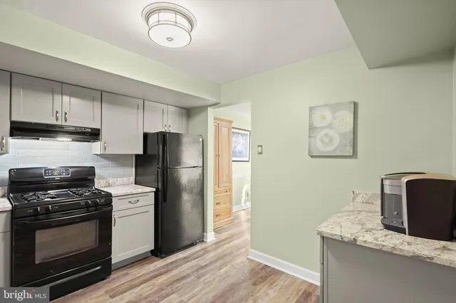 a kitchen with a refrigerator stove and white cabinets