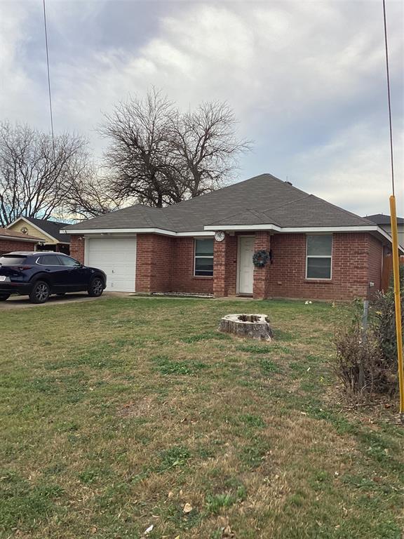 a front view of house with yard and trees in the background