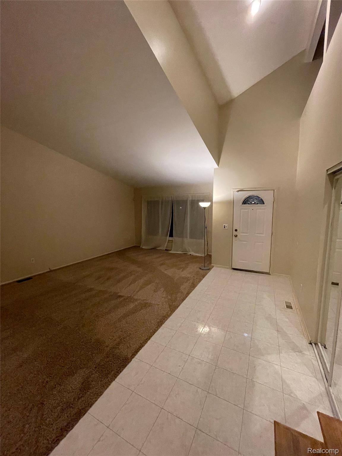 42195 Park Ridge Road Novi, MI 48375 - Photo 2 of 14 Vaulted ceilings, tiled entryway, carpeted living area, and a front entry door with an arched window