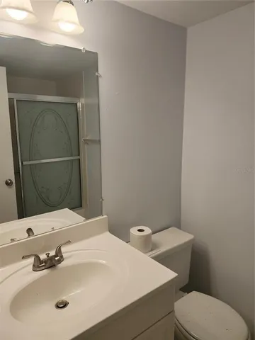 a bathroom with a sink a toilet and mirror