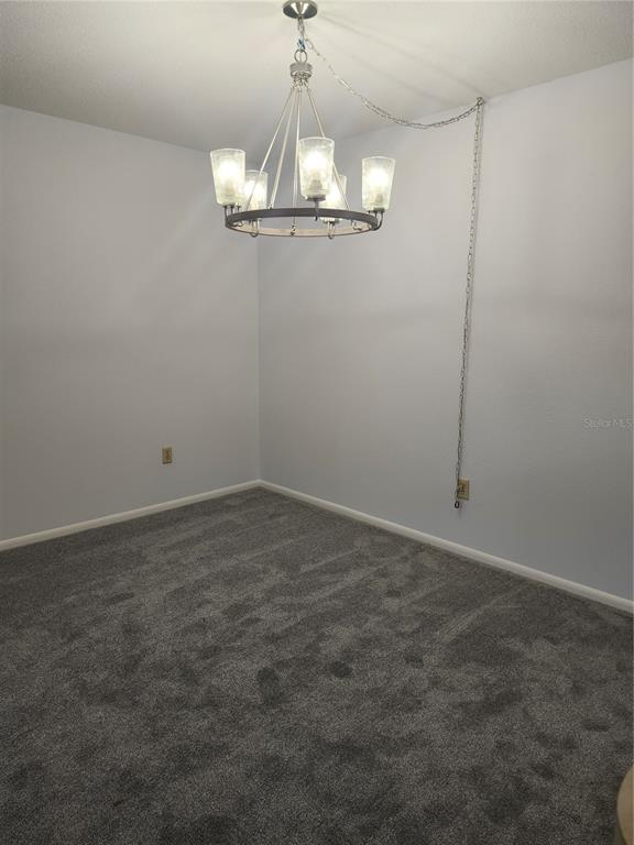 1515 Forrest Nelson Boulevard, Unit J104 Port Charlotte, FL 33952 - Photo 5 of 27 a view of a room with a chandelier fan and wooden floor