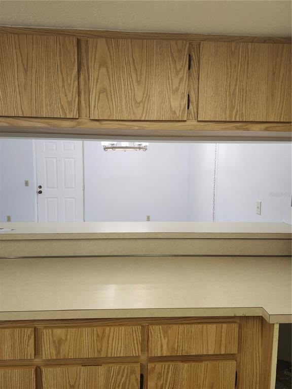 1515 Forrest Nelson Boulevard, Unit J104 Port Charlotte, FL 33952 - Photo 10 of 27 a view of kitchen cabinets and a wooden floor
